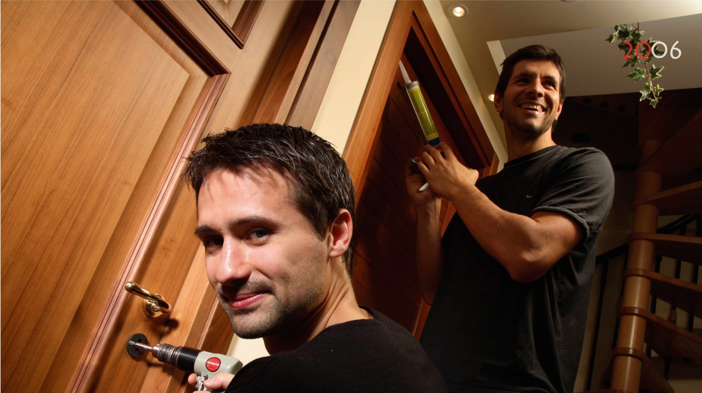 Due giocatori montano la maniglia e sigillano il telaio di una porta in legno